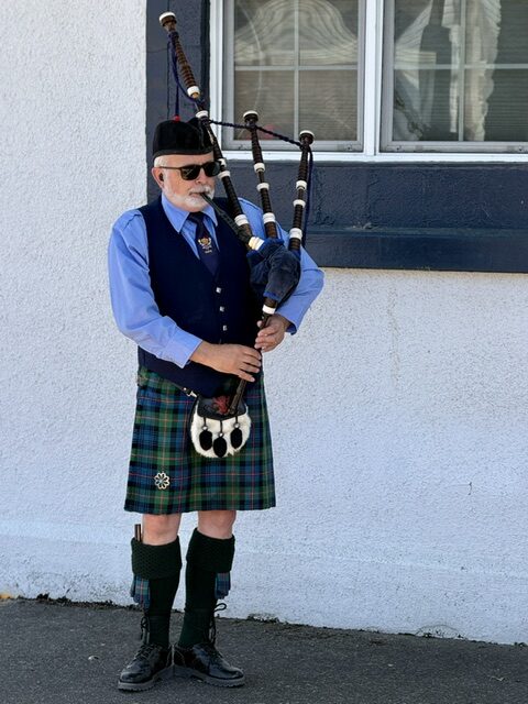 A bagpiper in Highland dress plays final honors at the Chief Woody Whetstone memorial dedication ceremony in Junction City, Oregon.